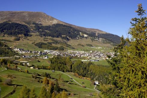 Bergdorf umgeben von Wiese