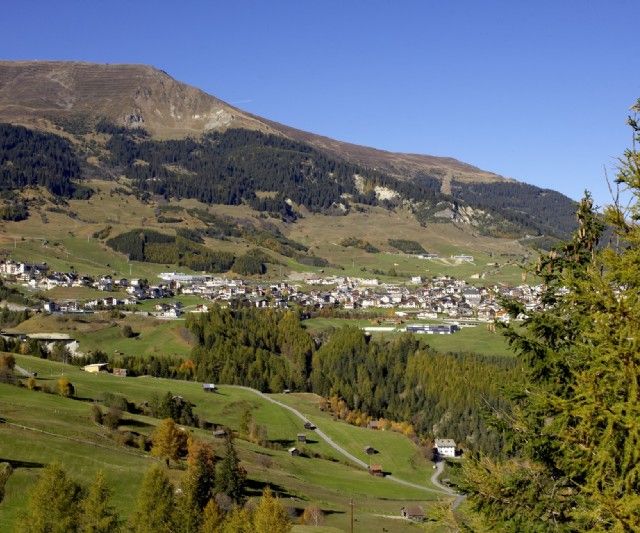 Bergdorf umgeben von Wiese